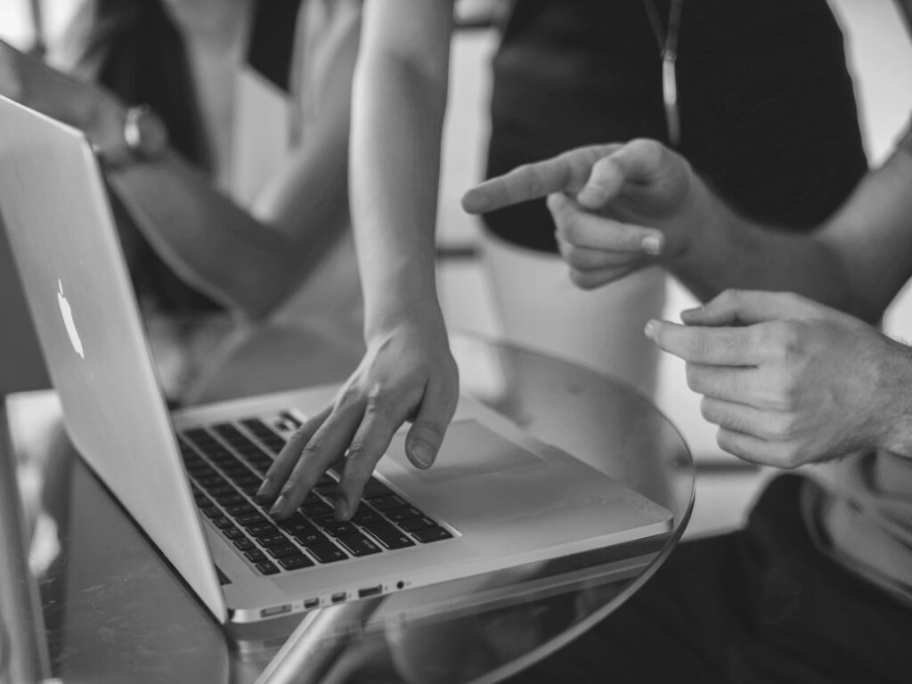 a person pointing at a laptop